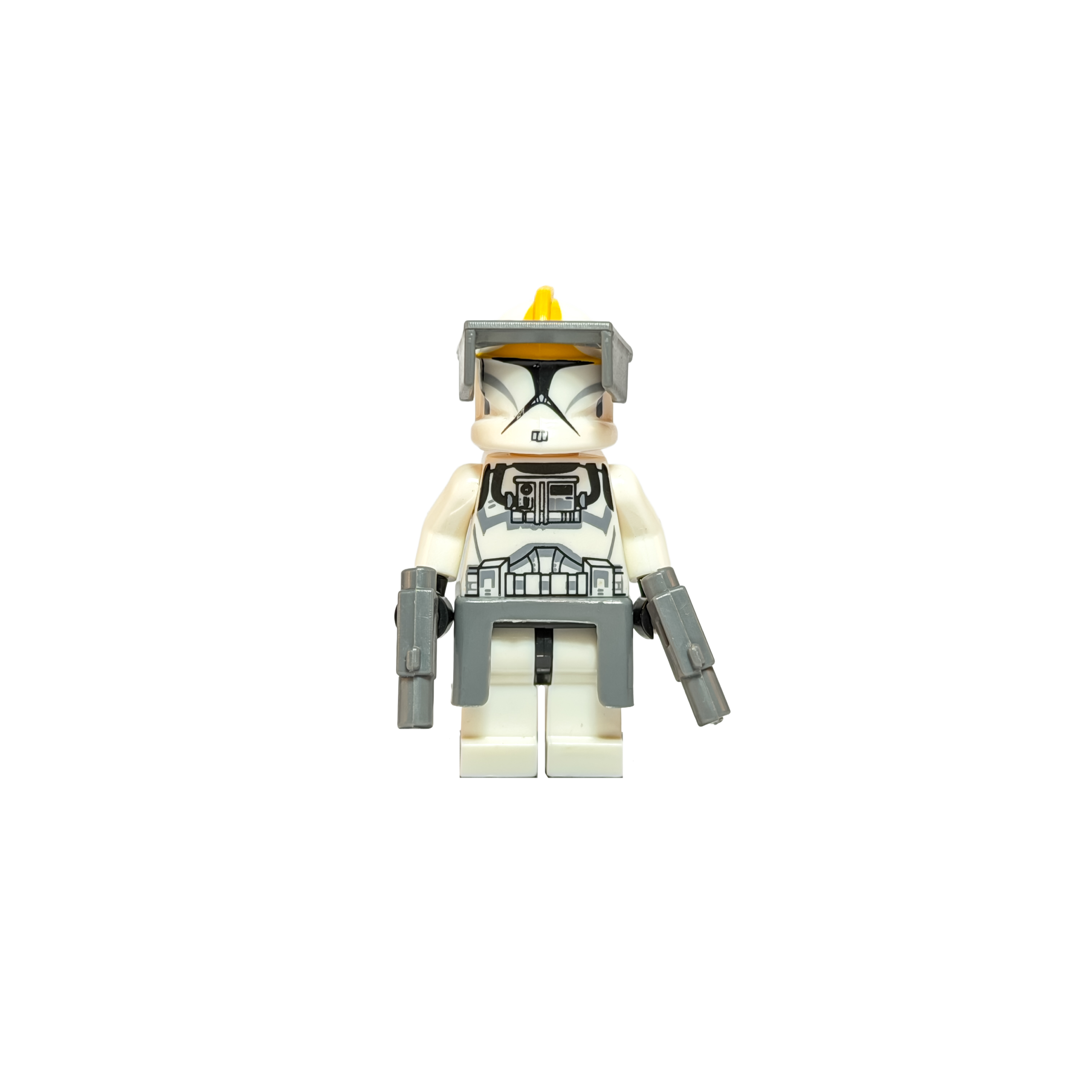 Minifigura de colección de un Soldado Clon Piloto de Star Wars con armadura Fase 1, sobre un fondo negro puro. Su casco blanco tiene una cresta amarilla y un visor táctico gris. Viste un torso con impresión de soporte vital, un faldón gris en la cintura y empuña dos pistolas bláster de color gris.