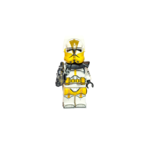 Minifigura de colección del Comandante Bly de Star Wars con armadura Fase 2, sobre un fondo negro puro. Luce una armadura blanca con marcas amarillas en el pecho, piernas y casco. Lleva un visor de macrobinoculares amarillo sobre el casco y una hombrera negra. Sostiene un rifle bláster negro apuntando hacia el frente.