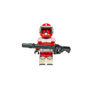 Minifigura de colección del Comandante Fox de Star Wars con armadura Fase 1, sobre un fondo negro puro. Luce una armadura predominantemente roja con acentos blancos en el pecho y piernas. Su casco rojo tiene una aleta superior y un visor táctico gris oscuro. Sostiene transversalmente con ambas manos un rifle bláster negro muy grande y pesado.