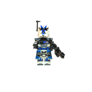 Minifigura de colección del ARC Trooper Dogma de la Legión 501 sobre un fondo negro puro. Viste una armadura blanca con detalles azules complejos y marcas de batalla. El casco tiene un diseño de "V" azul y un telémetro negro a un costado. Lleva hombreras tácticas y una falda de comando azul. Sostiene un rifle bláster largo y pesado hacia adelante en una pose de guardia.