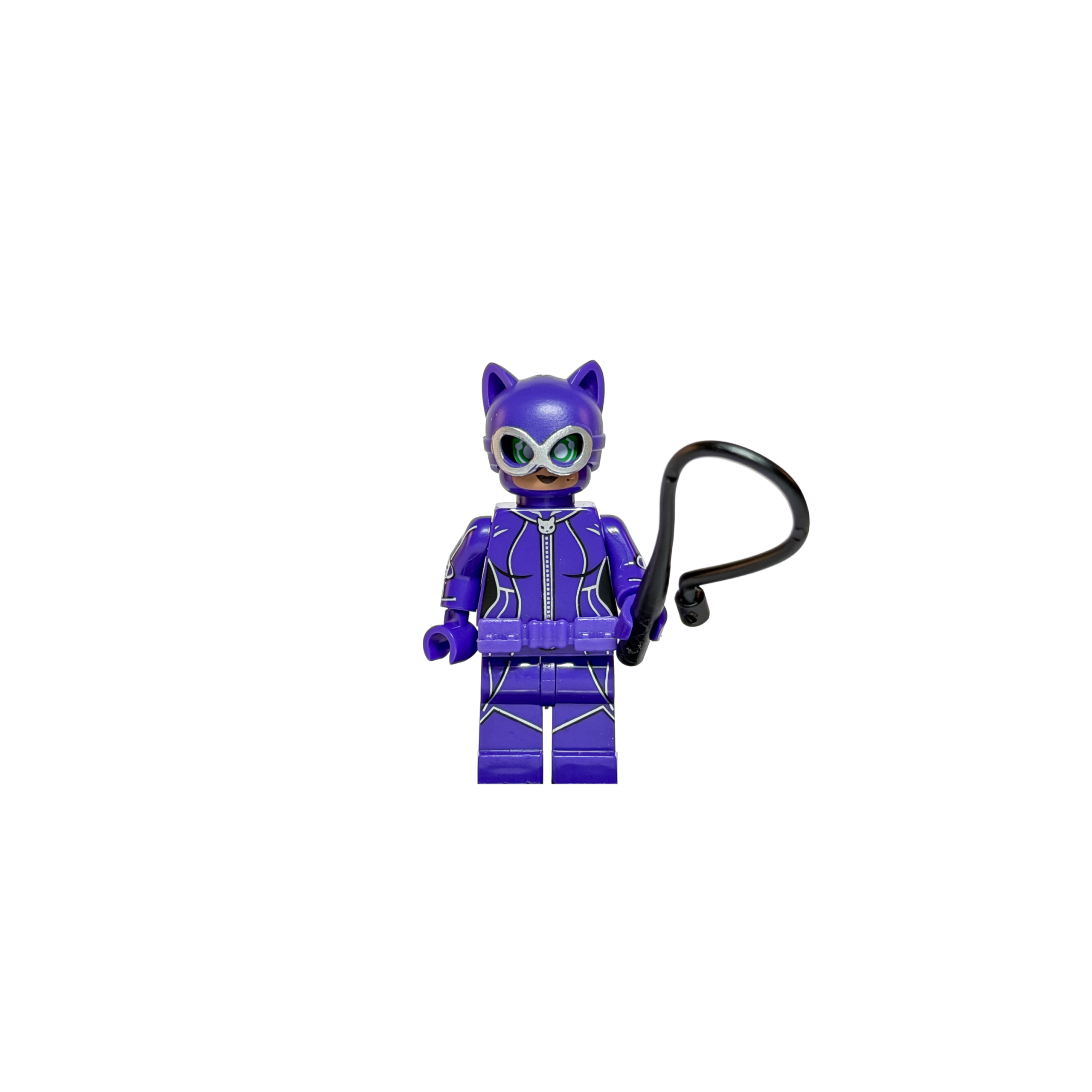 Minifigura de colección de Gatúbela (Catwoman) de DC Comics sobre un fondo blanco puro. Viste un traje púrpura brillante con detalles de líneas plateadas y un cinturón púrpura. Su máscara tiene orejas puntiagudas y antiparras con lentes verdes. Sostiene un látigo negro curvo en su mano izquierda y está parada sobre una base de exposición negra.