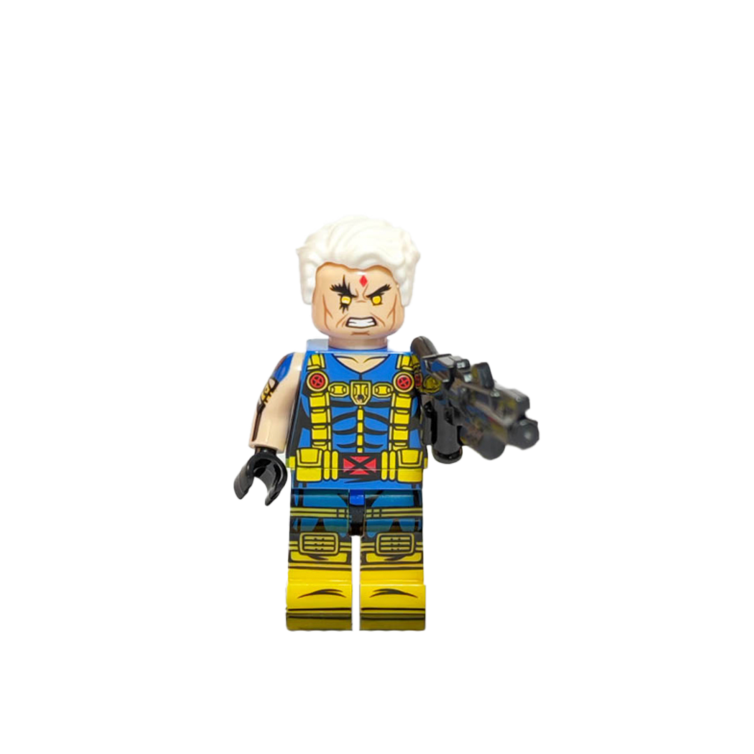 Minifigura de colección de Cable de Marvel X-Men, con brazo cibernético plateado, ojo brillante, traje táctico azul y amarillo, sosteniendo un rifle futurista grande sobre fondo blanco.