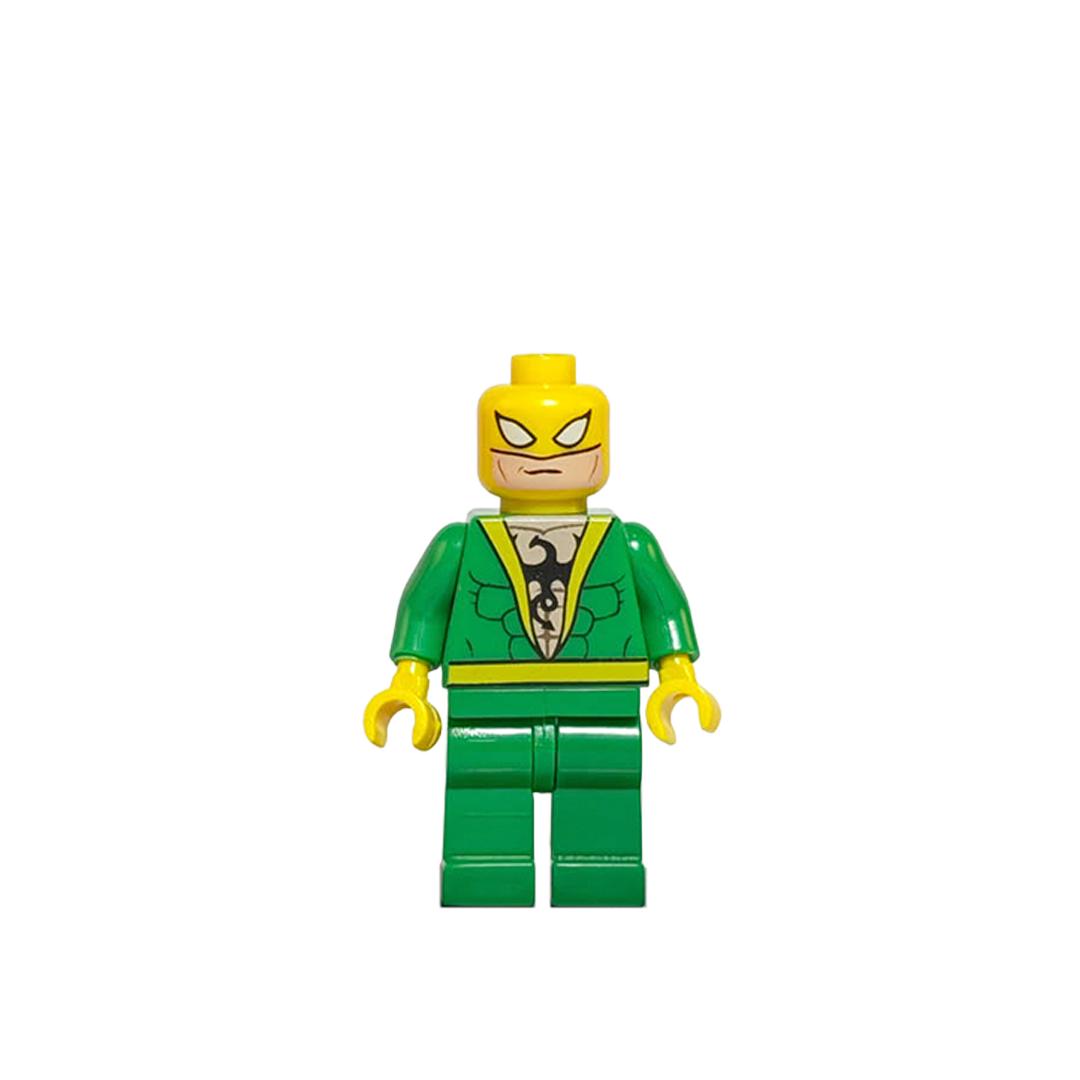 Minifigura de colección de Iron Fist (Danny Rand) de Marvel, vistiendo traje verde clásico con emblema de dragón negro en el pecho, máscara amarilla con bandana y portando un efecto translúcido de energía chi amarilla en su puño derecho, sobre fondo blanco.