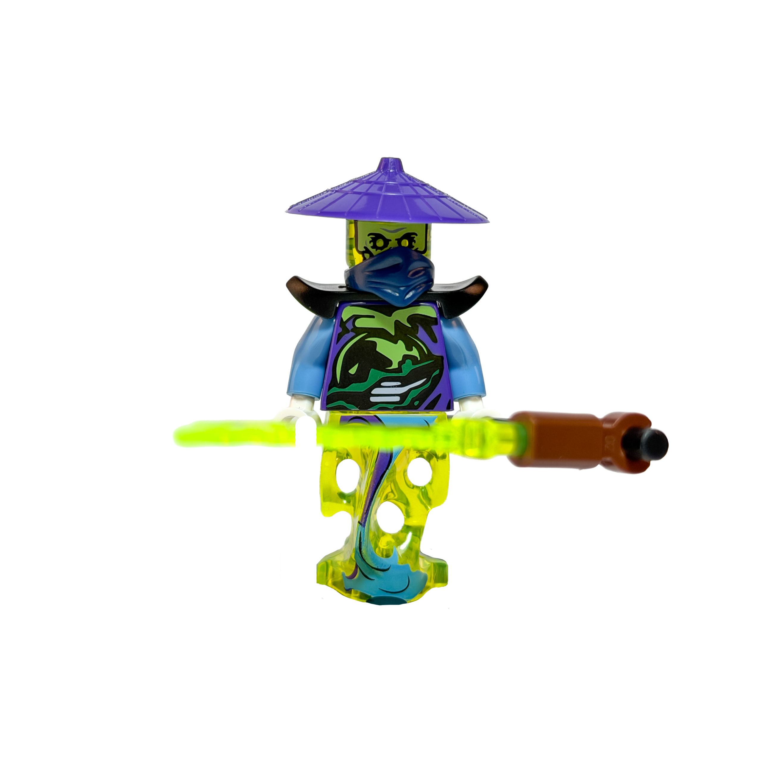 Minifigura de colección de Ghoultar de Ninjago sobre un fondo blanco puro. Es un fantasma con una base verde lima translúcida en lugar de piernas. Viste una túnica violeta con detalles de un dragón verde y una máscara azul. Lleva un sombrero cónico violeta y hombreras negras. Sostiene horizontalmente una guadaña larga con una hoja verde translúcida. Está parado sobre una base de exposición negra.